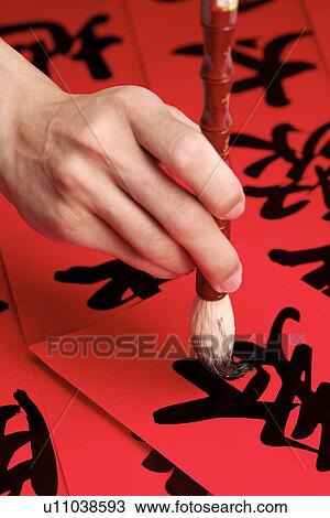 Stock Image - Close up of hand writing chinese script. Fotosearch