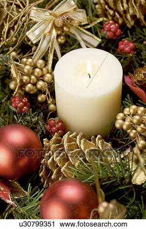 Lit candle surrounded with Christmas ornament View Large Photo Image Stock Image - Lit candle surrounded with Christmas ornament. Fotosearch