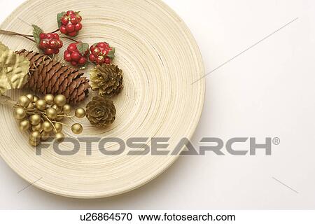 Stock Image - Pine cone and berries on plate. Fotosearch