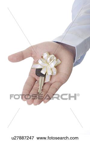 Stock Photo - Close-up of a key with bowknot on man's hand. Fotosearch