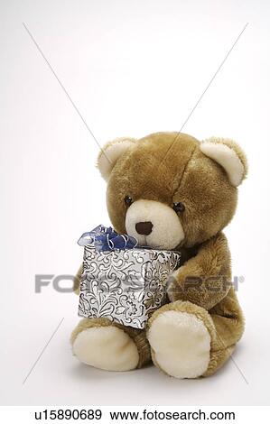 Close-up of a toy bear holding a wrapped gift View Large Photo Image Stock Photo - Close-up of a toy bear holding a wrapped gift. Fotosearch