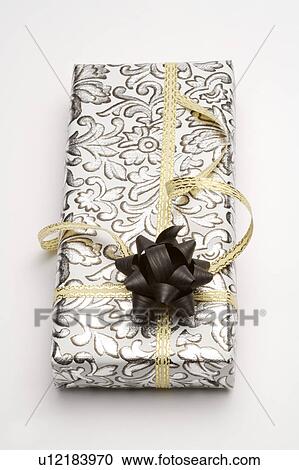 Stock Image - Close-up of a wrapped gift with beautiful packaging. Fotosearch