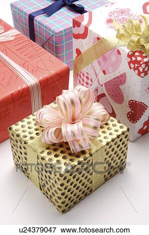 Stock Photo - Close-up of four wrapped gifts with beautiful packaging. Fotosearch