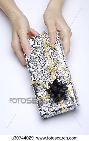 Stock Photo - Hands holding a wrapped gift. Fotosearch