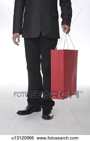 Man holding a red shopping bag View Large Photo Image Stock Photograph - Man holding a red shopping bag. Fotosearch
