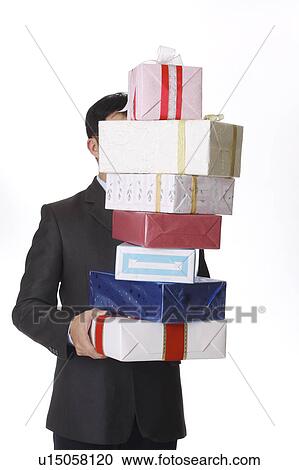 Man holding a stack of wrapped gifts View Large Photo Image Stock Image - Man holding a stack of wrapped gifts. Fotosearch