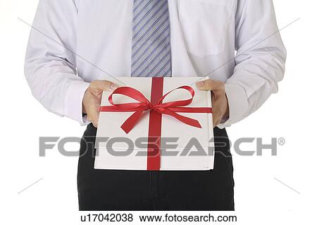 Man holding a wrapped gift View Large Photo Image Stock Photo - Man holding a wrapped gift. Fotosearch
