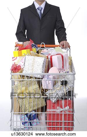 Man holding the push cart with many wrapped gifts View Large Photo Image Picture - Man holding the push cart with many wrapped gifts. Fotosearch