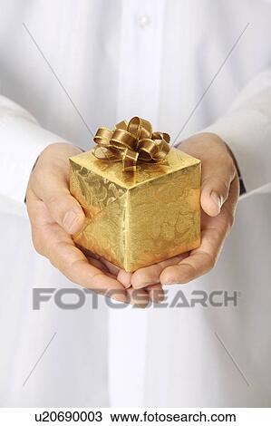 Man's hand holding a wrapped gift with beautiful packaging View Large Photo Image Stock Image - Man's hand holding a wrapped gift with beautiful packaging. Fotosearch