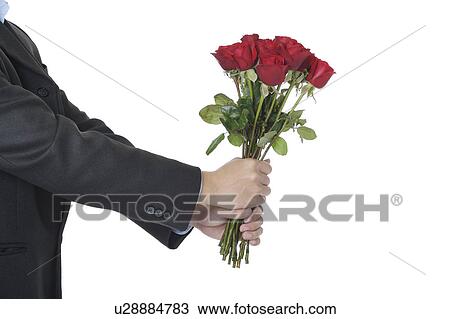 Stock Image - Man's hands holding a bouquet of red roses. Fotosearch