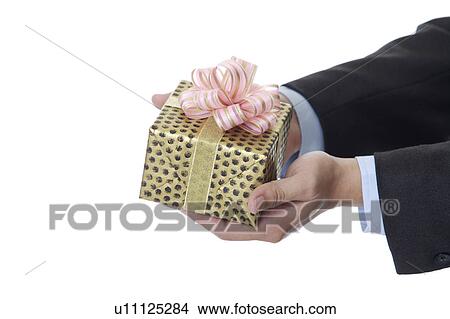 Picture - Man's hands holding a wrapped gift with beautiful packaging. Fotosearch