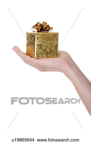 Woman's hand holding a wrapped gift, close-up View Large Photo Image Picture - Woman's hand holding a wrapped gift, close-up. Fotosearch