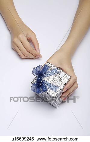 Woman's hand holding a wrapped gift View Large Photo Image Stock Photography - Woman's hand holding a wrapped gift. Fotosearch