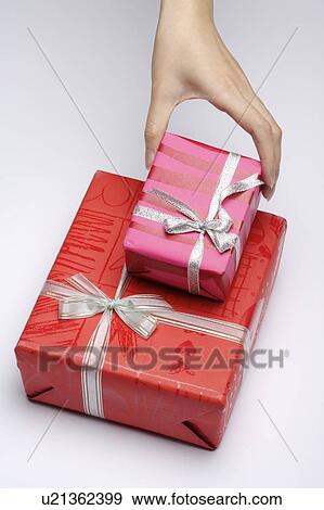Stock Photo - Woman's hand holding wrapped gifts. Fotosearch