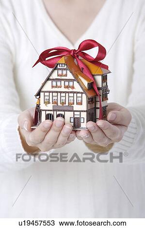 Woman's hands holding a house model as a gift View Large Photo Image Stock Image - Woman's hands holding a house model as a gift. Fotosearch