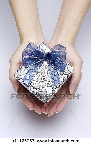 Woman's hands holding a wrapped gift View Large Photo Image Stock Photo - Woman's hands holding a wrapped gift. Fotosearch