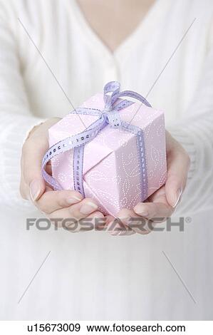 Woman's hands holding a wrapped gift View Large Photo Image Stock Photo - Woman's hands holding a wrapped gift. Fotosearch