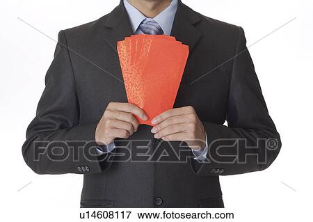 Stock Photo - Young man holding a stack of red envelopes. Fotosearch