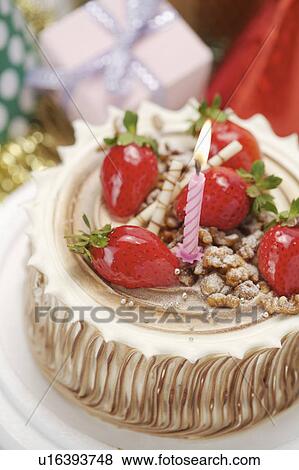 Stock Photo - Close-up of a birthday cake with strawberries and candle on it. Fotosearch