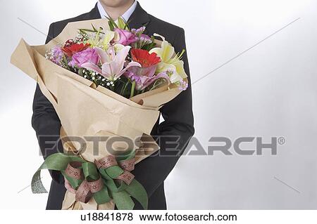 Man holding a bouquet of beautiful flowers View Large Photo Image Stock Photo - Man holding a bouquet of beautiful flowers. Fotosearch