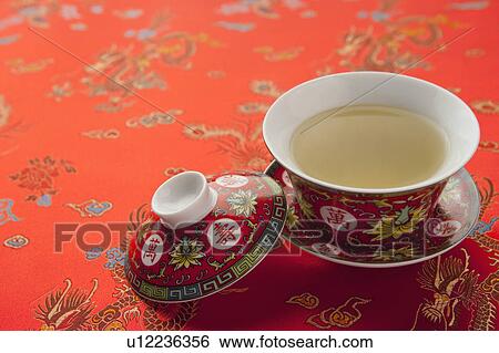 Stock Photograph - Close-up of a cup of tea on textile with lucky pattern of Chinese style. Fotosearch