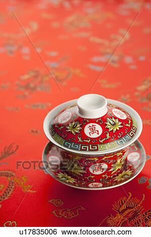 Stock Photograph - Close-up of a teacup on red textile of lucky patterns. Fotosearch