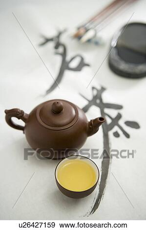 Stock Photo - Close-up of a teapot and two cups of tea with calligraphy. Fotosearch