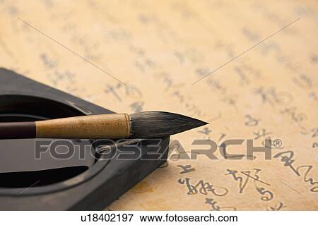 Stock Photo - Close-up of ink brush on inkstone. Fotosearch