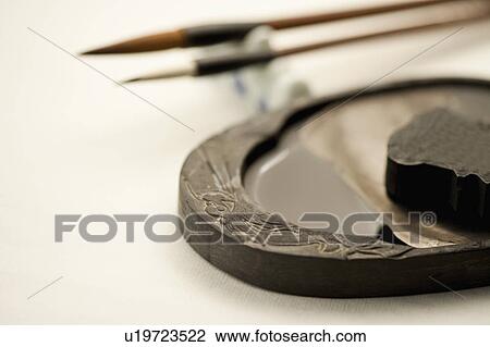 Stock Image - Close-up of inkstone with ink and ink brushes. Fotosearch