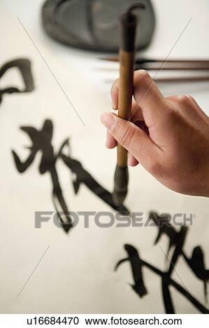 Human hand holding ink brush and writing calligraphy View Large Photo Image Stock Image - Human hand holding ink brush and writing calligraphy. Fotosearch