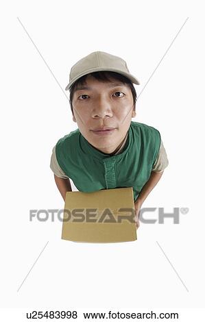 Delivery-person holding a box and looking at the camera View Large Photo Image Stock Photo - Delivery-person holding a box and looking at the camera. Fotosearch