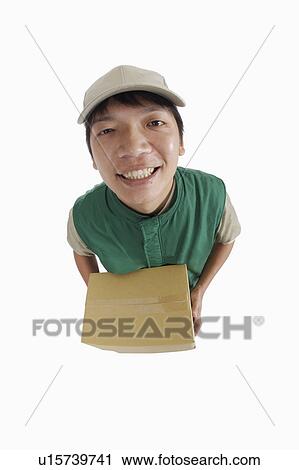 Delivery person holding a carton and looking at the camera View Large Photo Image Stock Image - Delivery person holding a carton and looking at the camera. Fotosearch