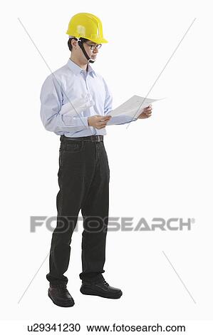 Engineer holding blueprint and looking at it View Large Photo Image Stock Image - Engineer holding blueprint and looking at it. Fotosearch