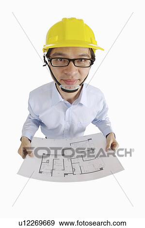 Male engineer holding blueprint and looking at the camera View Large Photo Image Stock Photo - Male engineer holding blueprint and looking at the camera. Fotosearch