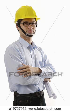 Stock Image - "Male engineer holding blueprints, portrait". Fotosearch