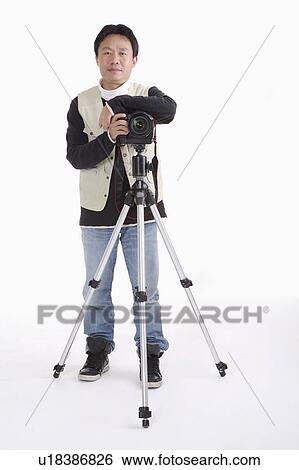 Photographer with camera on the tripod View Large Photo Image Stock Photograph - Photographer with camera on the tripod. Fotosearch