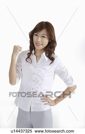 Stock Photography - Young female journalist standing with arms akimbo and fist up. Fotosearch