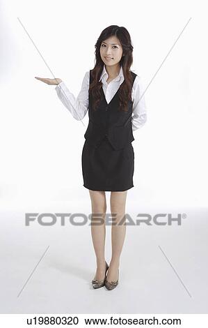 Young female office worker standing with one hand reaching out View Large Photo Image Stock Image - Young female office worker standing with one hand reaching out. Fotosearch
