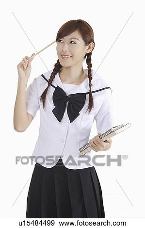 Young female student holding a pencil and books View Large Photo Image Stock Photo - Young female student holding a pencil and books. Fotosearch