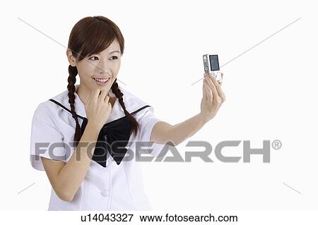 Stock Photo - Young female student taking picture by herself. Fotosearch