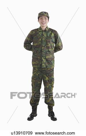 Stock Photo - Young male army soldier standing with hands on back. Fotosearch