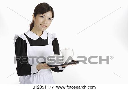Stock Photo - Young waitress holding a tray with teapot and teacup. Fotosearch