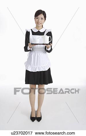 Young waitress holding a tray with teapot and teacup View Large Photo Image Stock Photo - Young waitress holding a tray with teapot and teacup. Fotosearch