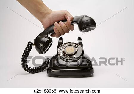 Stock Photograph - A hand holing a landline Phone. Fotosearch