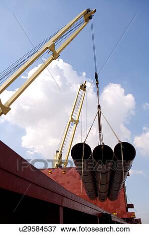 Crane Offloading Pipe from Cargo Ship View Large Photo Image Stock Photo - Crane Offloading Pipe from Cargo Ship. Fotosearch