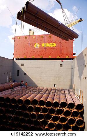 Stock Image - Offloading Pipe from Cargo Ship. Fotosearch