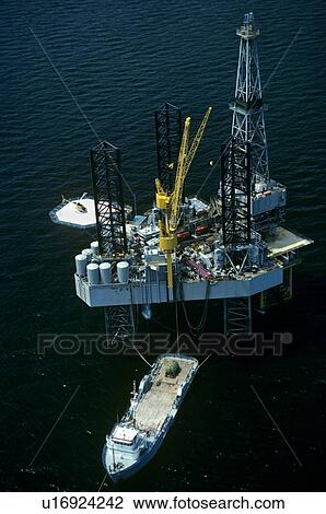 Stock Image - Offshore Oil Drilling Rig with Supply Boat Offloading. Fotosearch