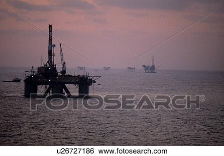 Offshore Oil Drilling Rigs at Sunset View Large Photo Image Stock Photograph - Offshore Oil Drilling Rigs at Sunset. Fotosearch