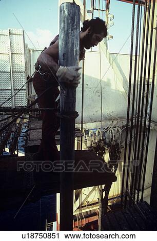 Stock Image - Offshore Oil Rig Worker Handling Drill Pipe in Derrick. Fotosearch