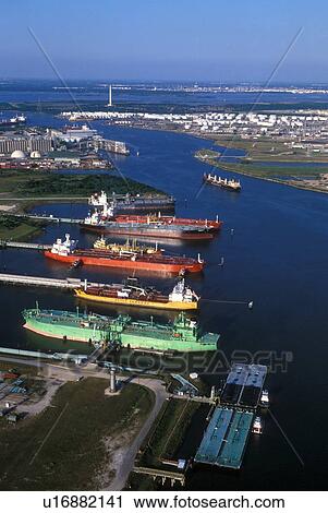 Stock Image - Oil Tankers Offloading in Houston Ship Channel with San Jacinto Monument in Background. Fotosearch